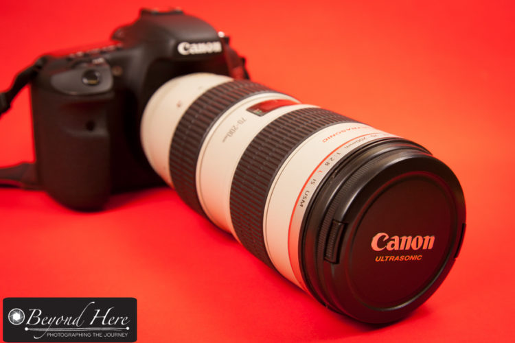 Canon 70-200mm lens on dslr with red background