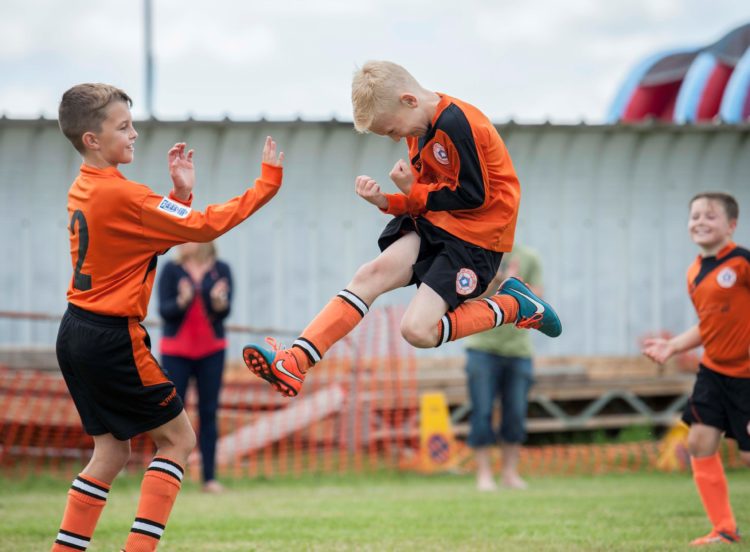 Junior football celebration. Sports photographer Sally Jacob.